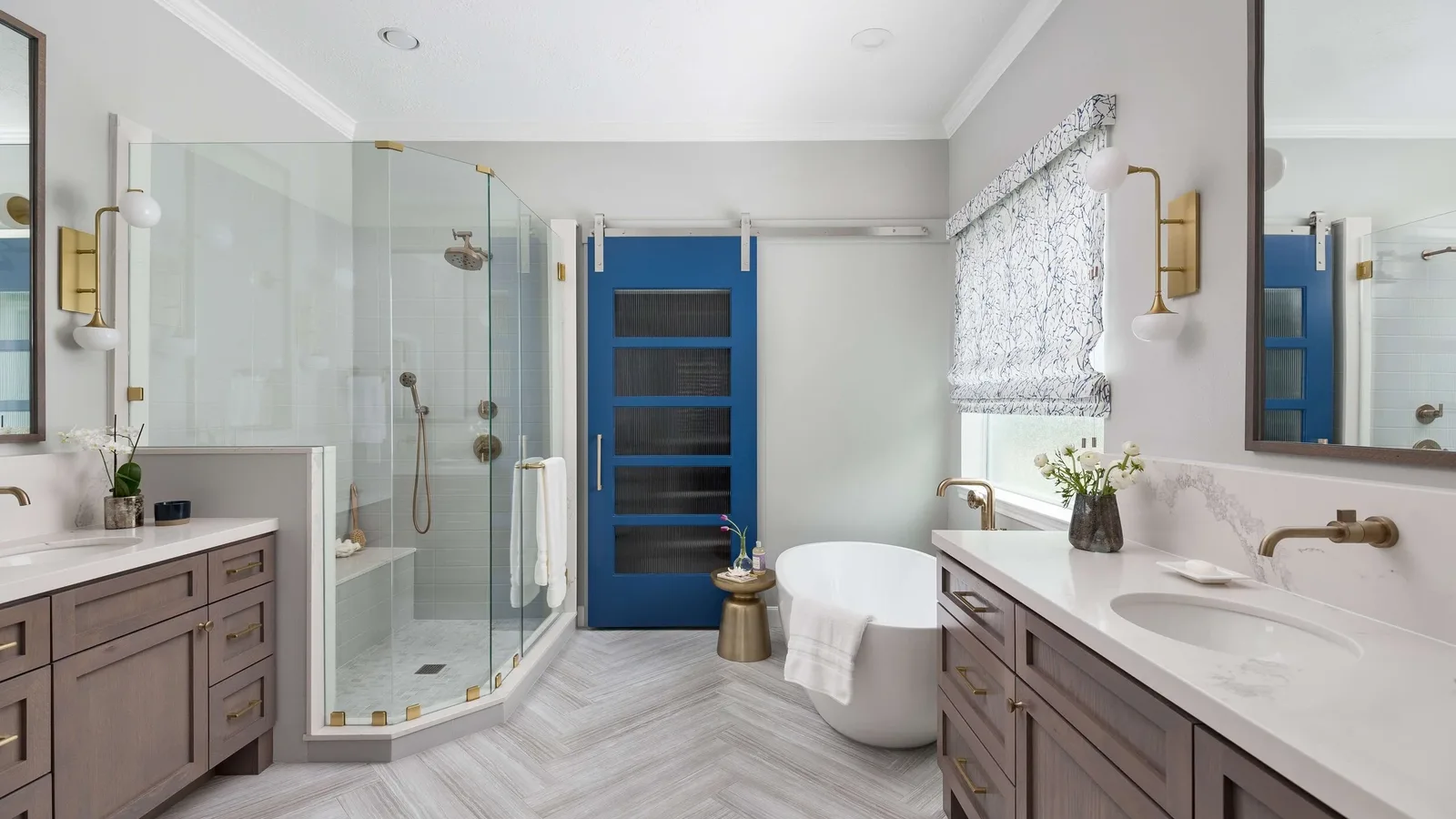 Finished bathroom with a glass tile shower, a freestanding tub and twin vanities
