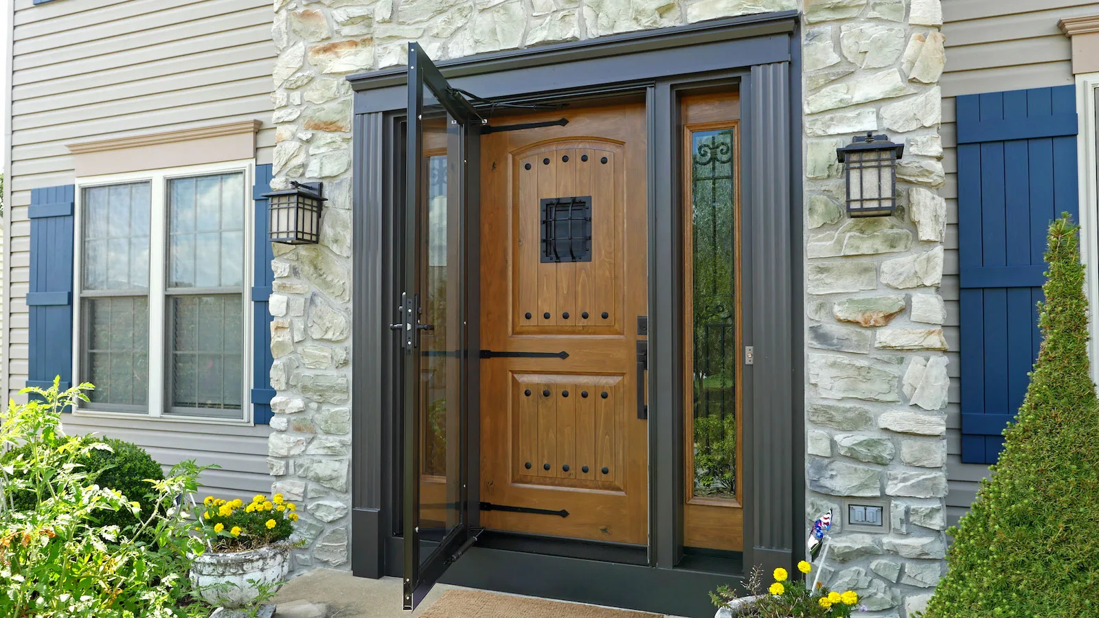 Newly installed wood entry door with a full-view storm door on the front of a home