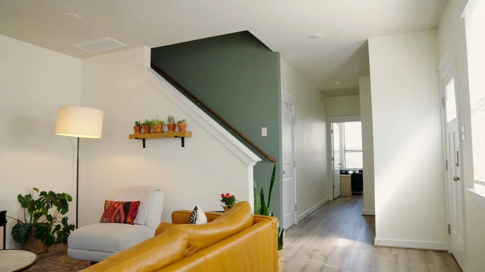 Interior with freshly painted white walls and a green accent wall over new plank flooring